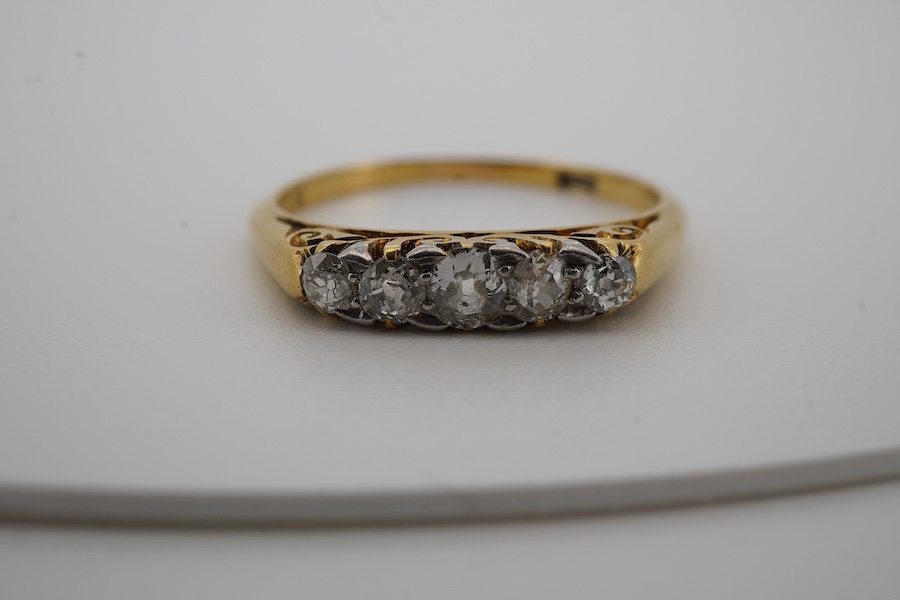 An early 20th century yellow metal and graduated five stone diamond set half hoop ring, size N, gross weight 2 grams. Condition - fair